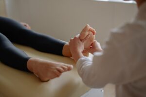 Close-up of a foot massage therapy session with a therapist working on a client's foot.